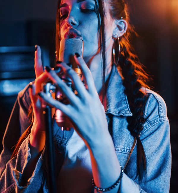 Young beautiful female singer rehearsing in a recording studio