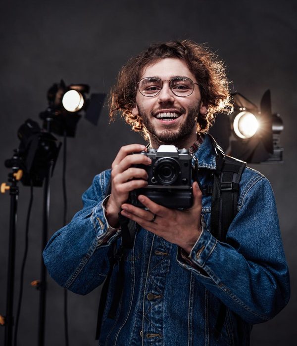 young-photographer-holds-a-camera-studio-portrait-resize.jpg